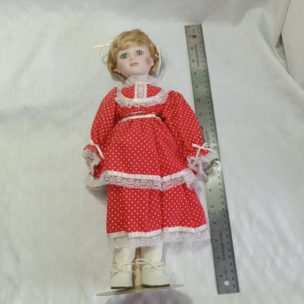 Beautiful 17-inch porcelain doll in perfect condition with red dress with white